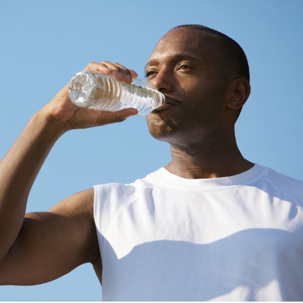 A man drinks from a bottle of water on a hot day.