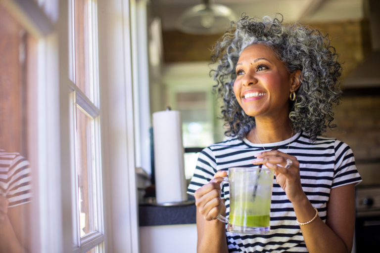 Woman happy, drinking green smoothie