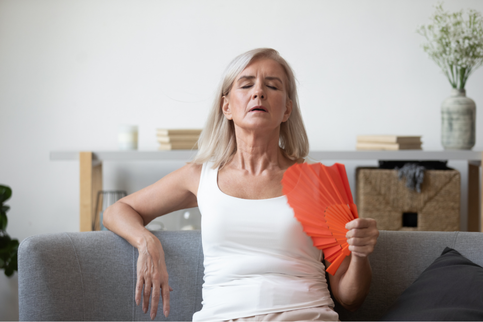 Mature woman, fanning herself, experiencing hot flash