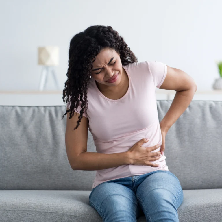 Women holding her side in pain where the kidney is located.